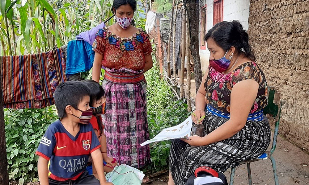 Teacher Teresa Azucena González Tuch visits the home of her students in San Pedro La Laguna, Guatemala. Child Aid's online teacher training has helped Teresa support her students during Covid-19.