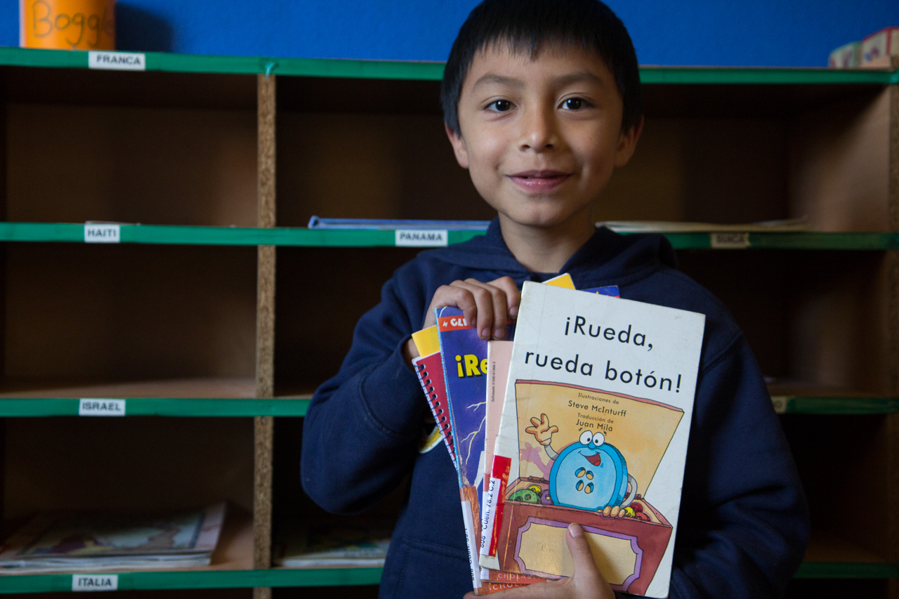 Participants in the Tzumpago Adventures in Reading were able to check out books to read at home. A boy shows off his selections. 