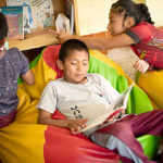 Child Aid literacy trainer Heidi Coyote Mactzul reads to a group of kids.