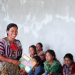 Hermelinda reading to girls in El Llano, Guatemala